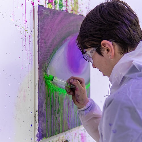 A woman using a syringe for painting